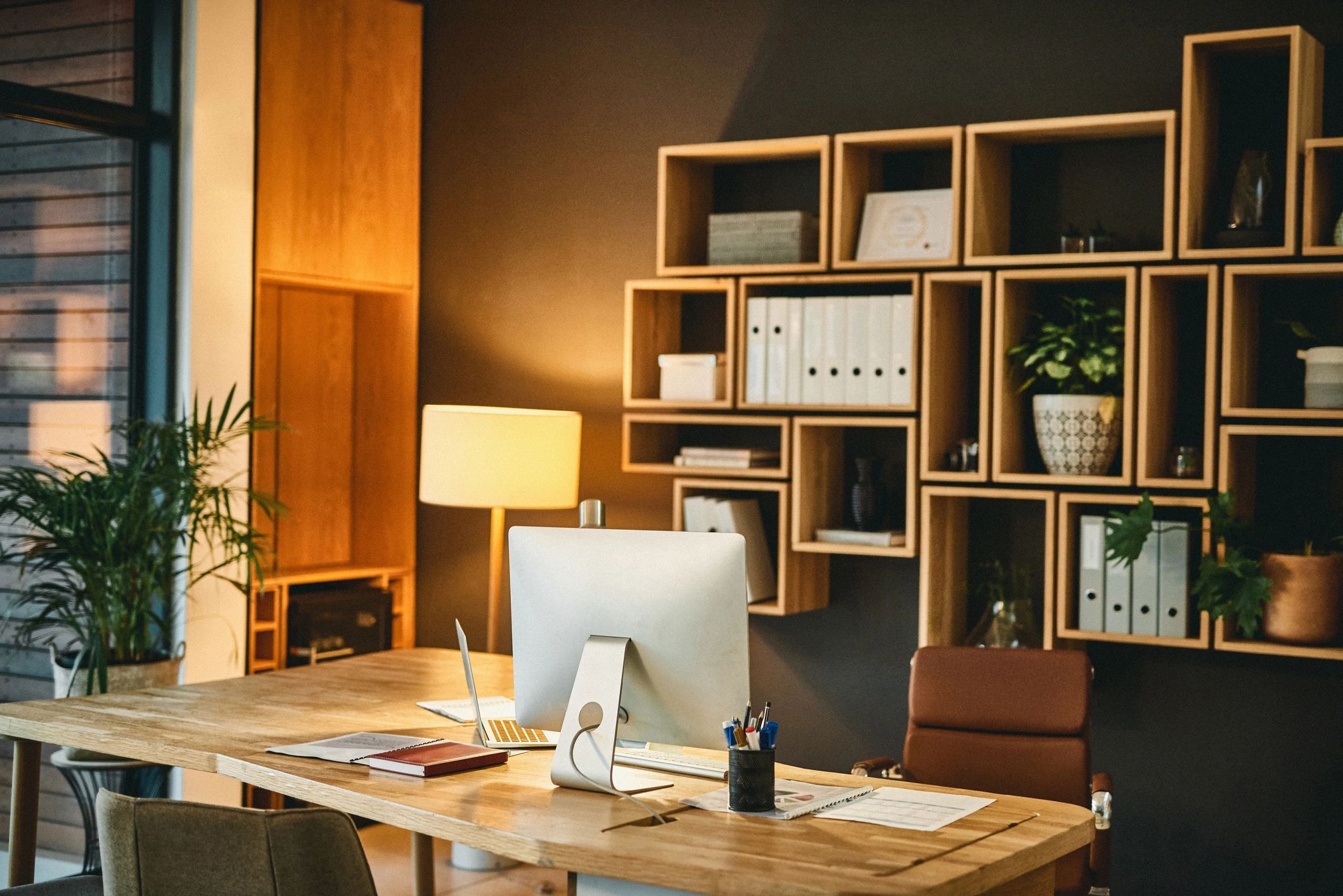 Dark desk and quiet office interior with restrained editorial mood