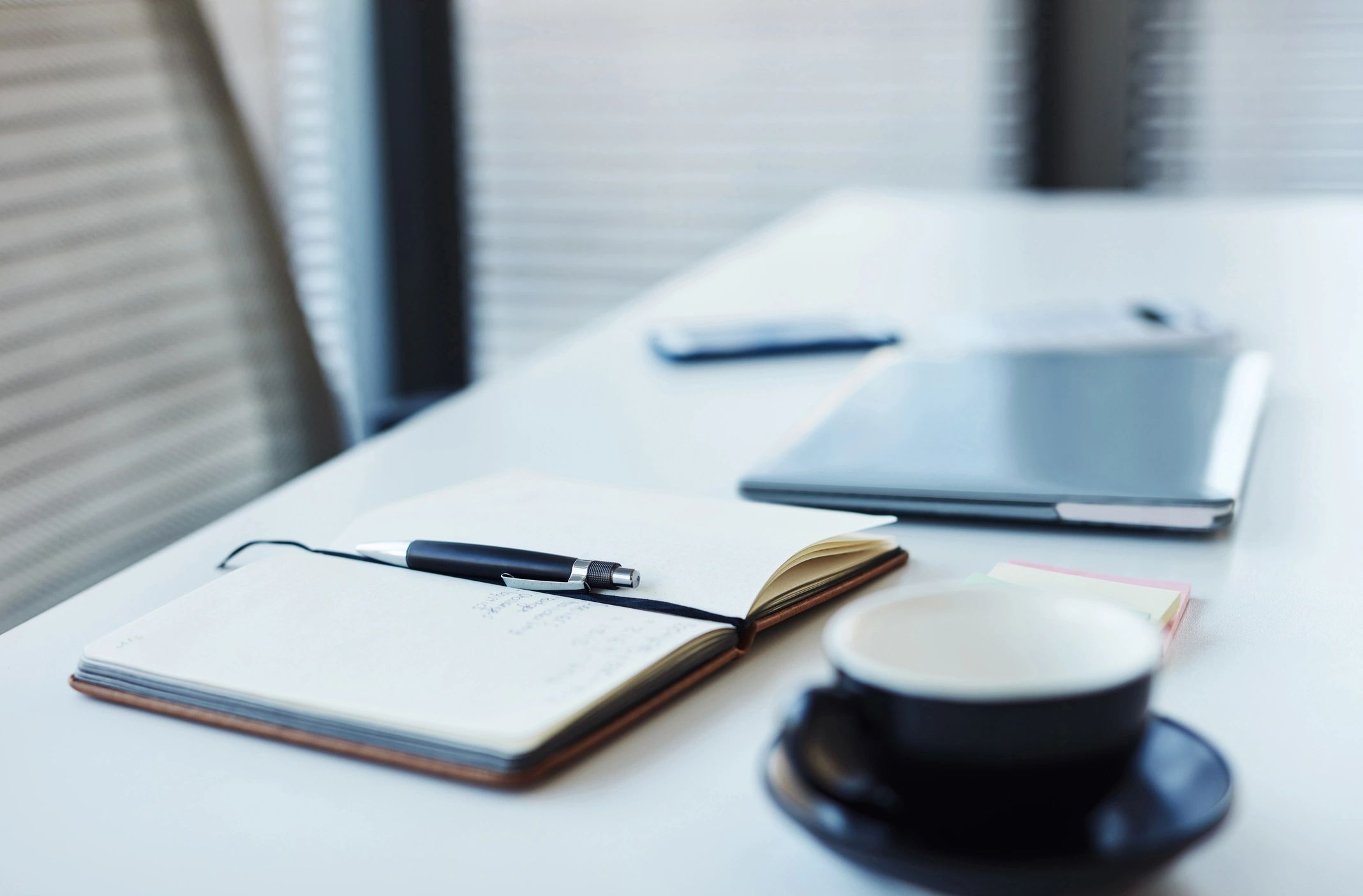 Notebook and laptop on a dark office desk