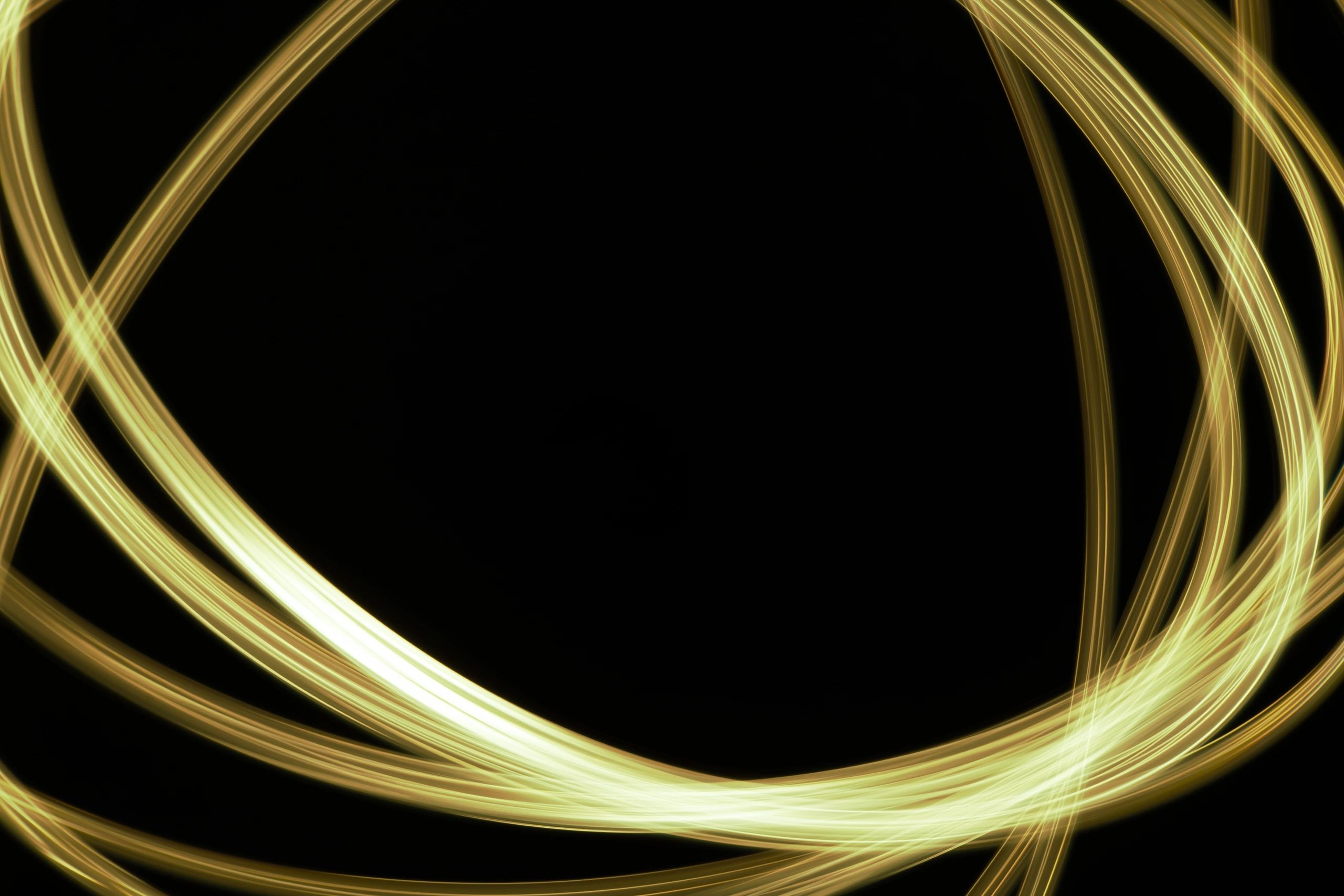 Abstract gold light trails on a black background